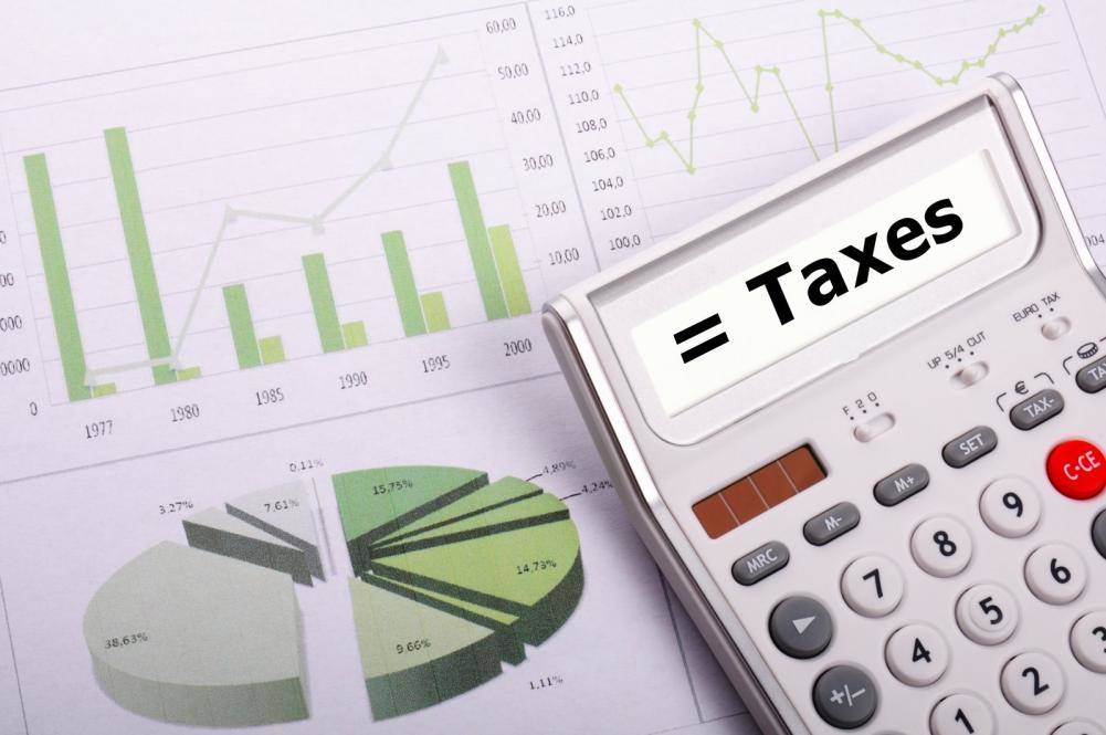 tax or taxes concept with business calculator and word